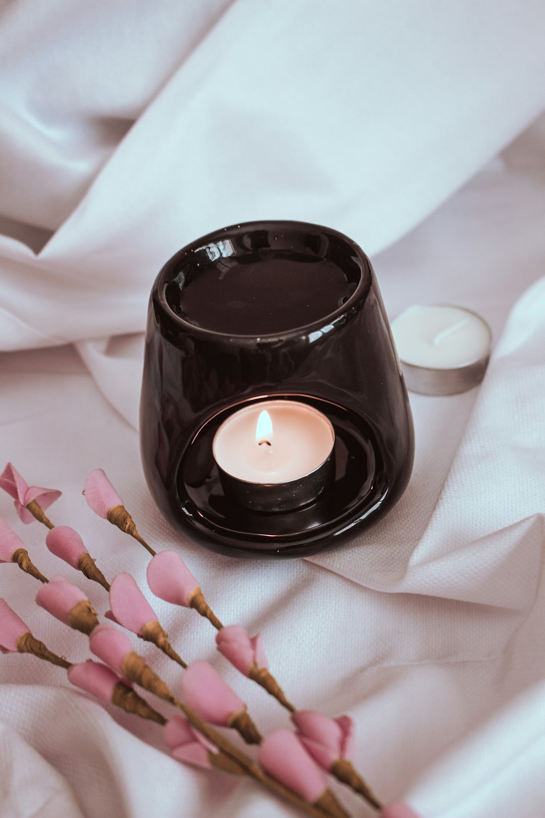 lighted candle in black round container