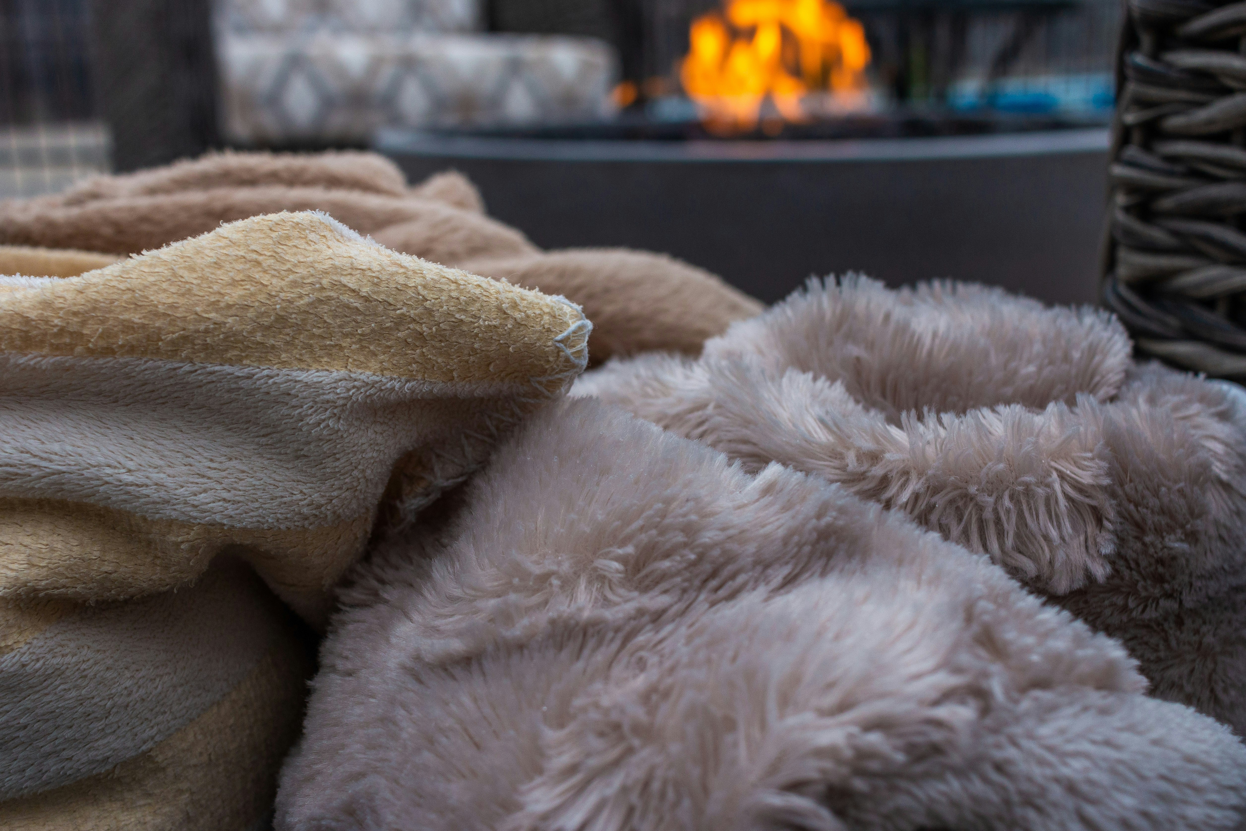 White fur textile near black metal fence