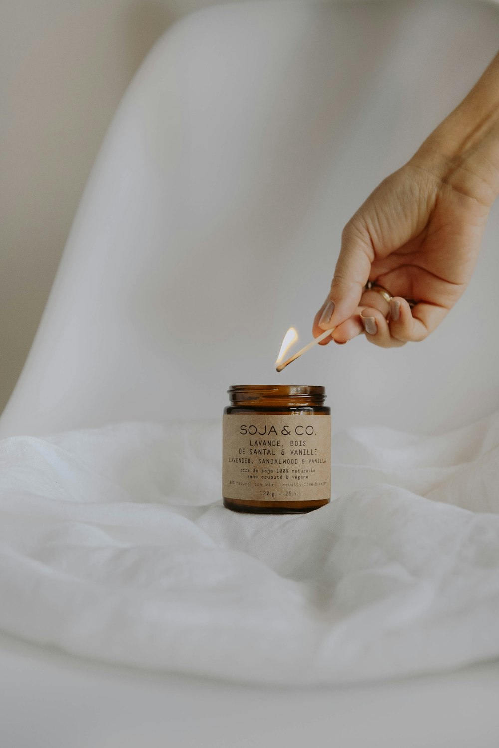 person holding white and black labeled glass jar