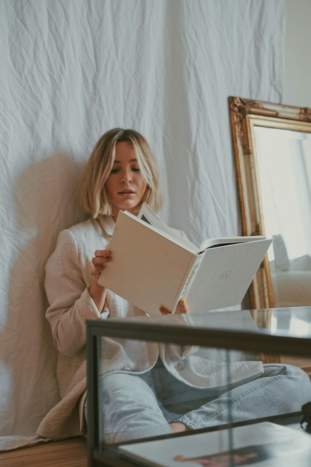 woman in white long sleeve shirt holding white tablet computer