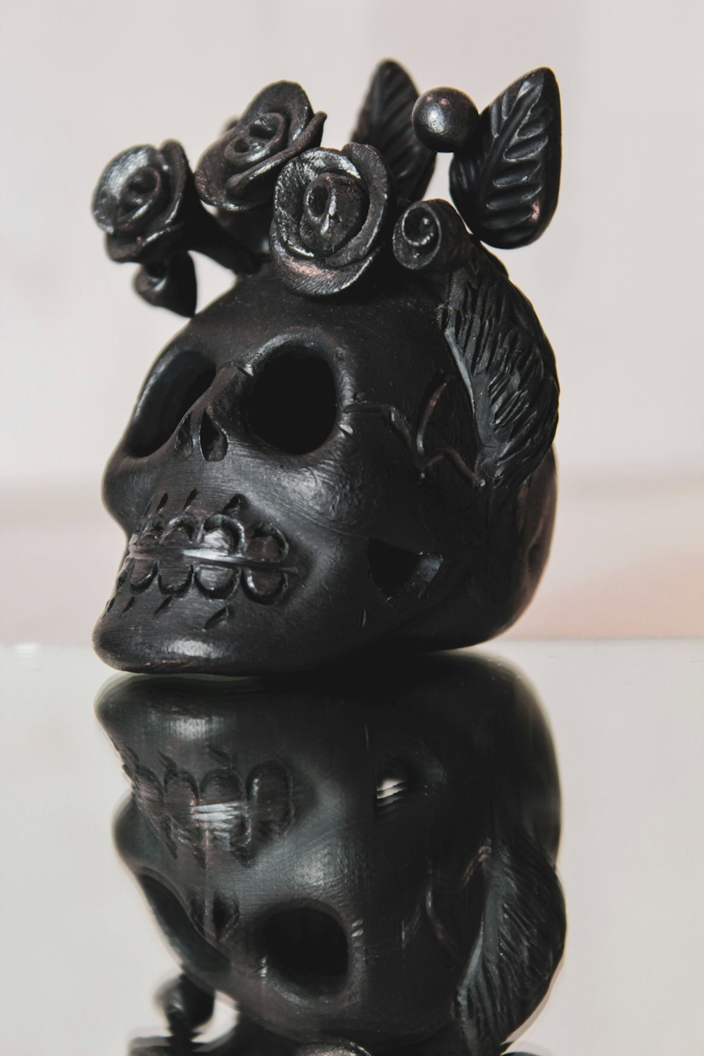 Figurine de crâne en céramique noire sur table blanche