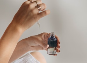 person holding black glass bottle