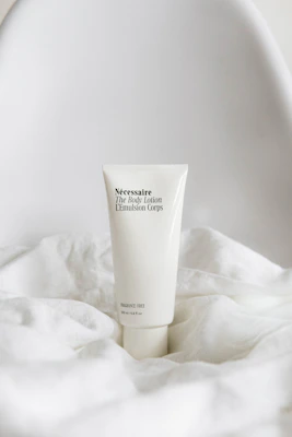 Elegant bottle of hand body lotion placed on a minimalist white surface with gentle lighting.