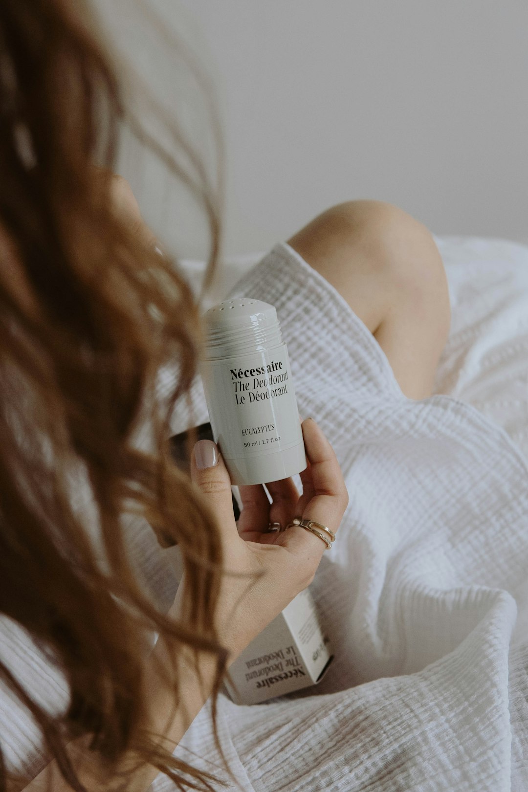 woman holding white plastic bottle