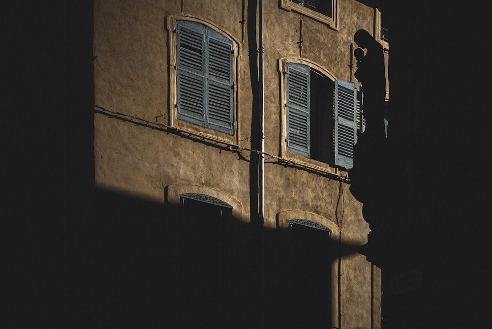 edificio in cemento marrone con persiane per finestre