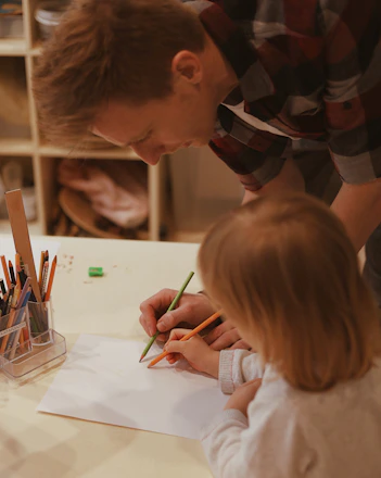 A calm parent and child using a colorful visual schedule together at home.