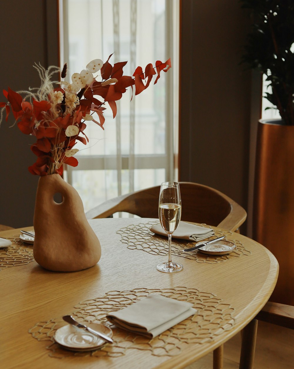 red flowers in clear glass vase on brown wooden table