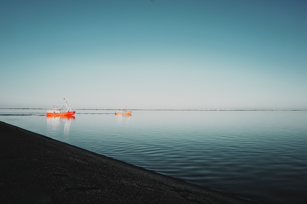 bateau rouge sur la mer sous le ciel bleu pendant la journée