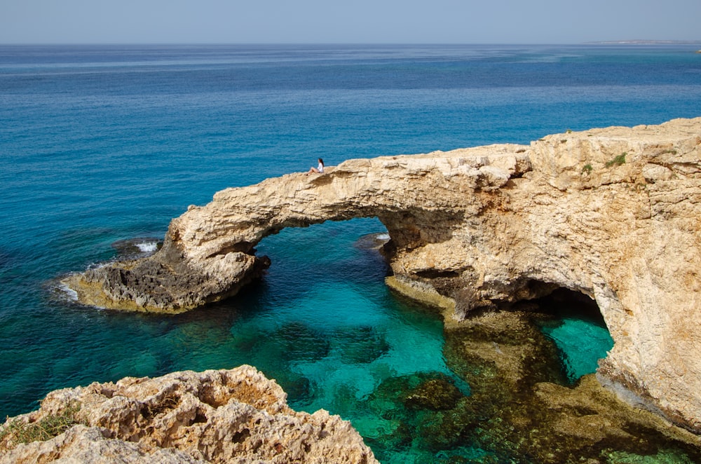 brown rock formation on blue sea under blue sky during daytime