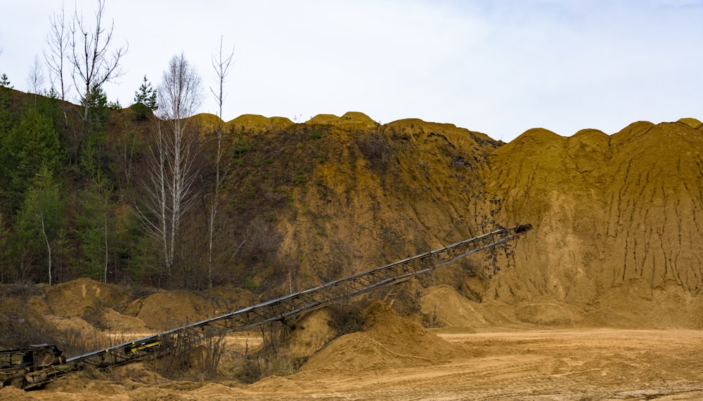 black metal rod on brown field near brown mountain during daytime