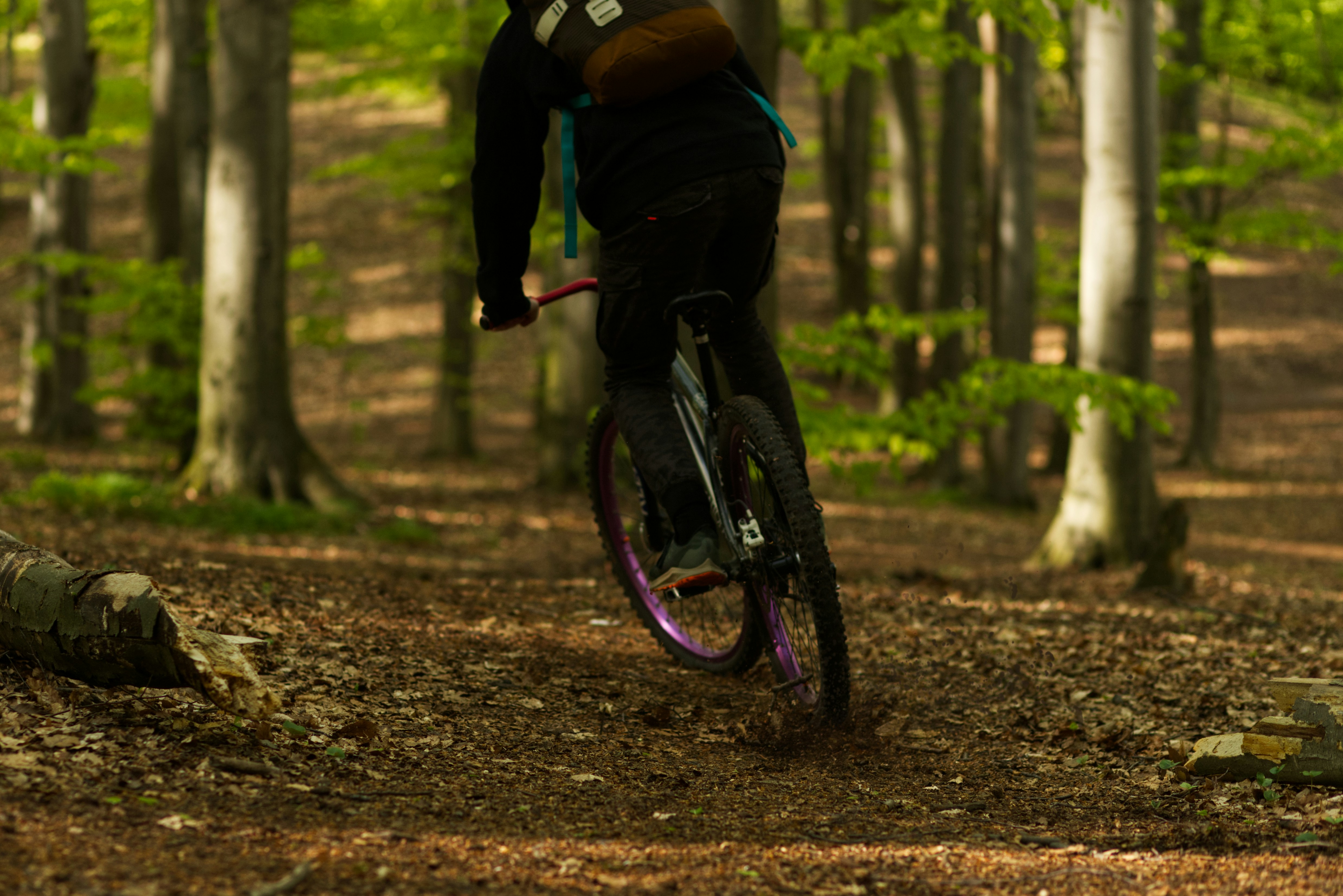 man in black jacket riding bicycle on forest during daytime