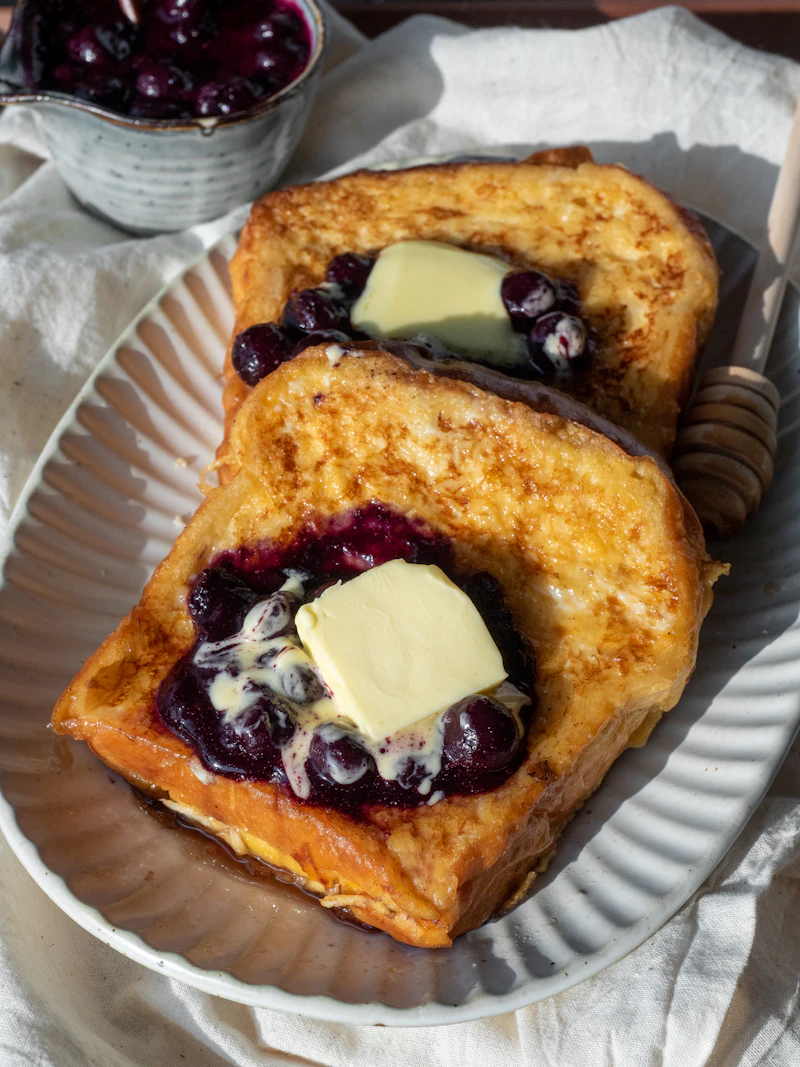 Thick slices of pain perdu topped with butter and berry compote