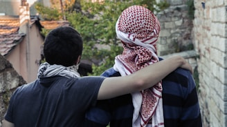 man in black shirt hugging woman in white and red hijab