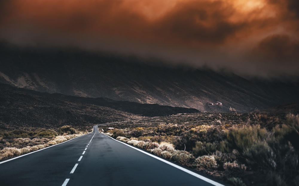 black asphalt road near snow covered mountains during daytime