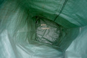 Inside a green textured bag, the words 'SELF ESTEEM' are arranged using wooden letter tiles. The perspective is from inside the bag looking toward the bottom.
