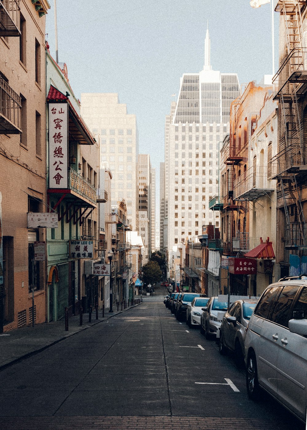 cars parked on sidewalk near buildings during daytime