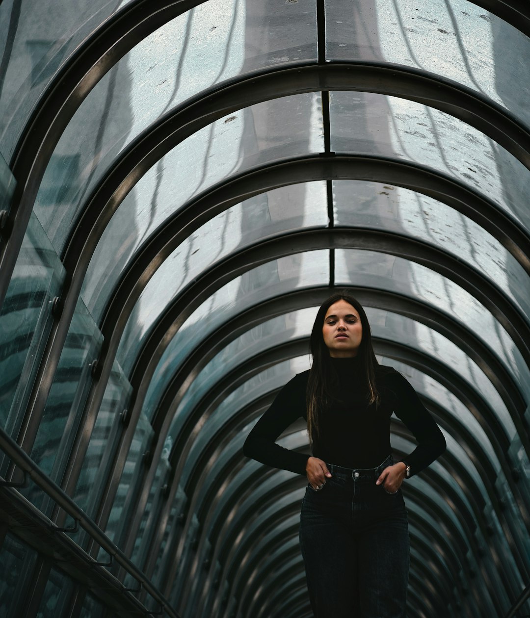 woman in black long sleeve shirt and black pants standing on tunnel