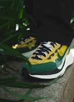 A close-up of vibrant sneakers on a city sidewalk.