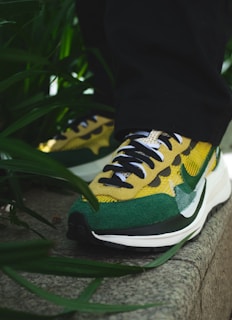 A close-up of vibrant sneakers on a city sidewalk.
