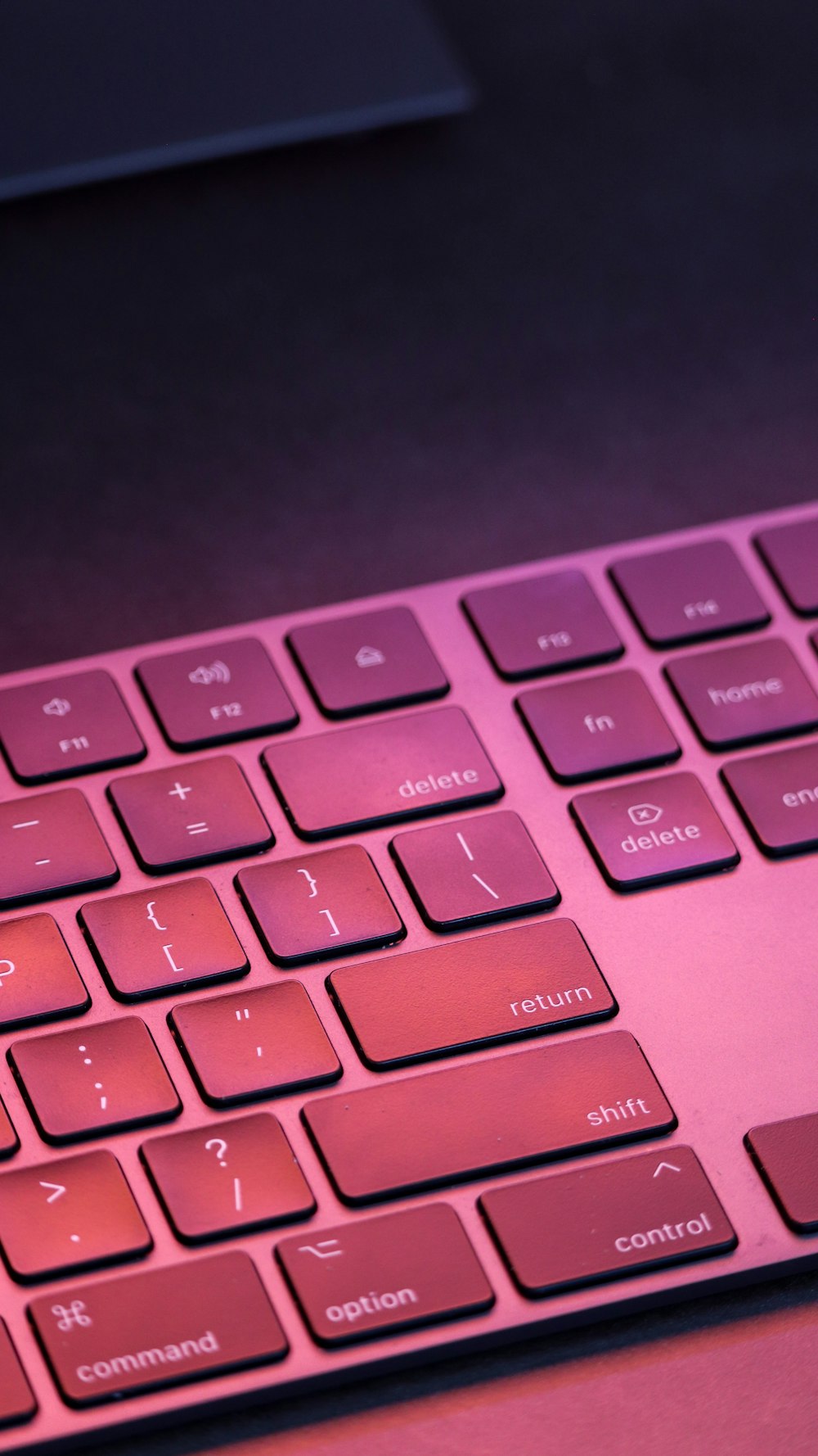 pink computer keyboard on black surface
