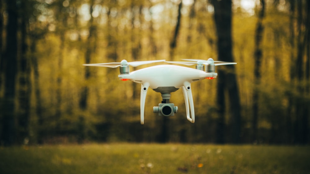 white and red drone flying during daytime