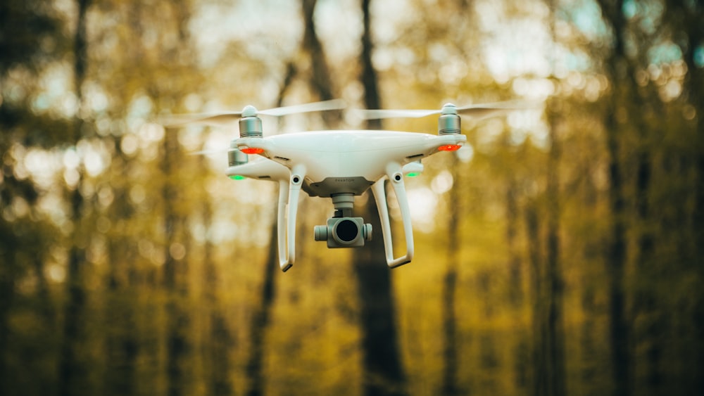 white drone flying during daytime