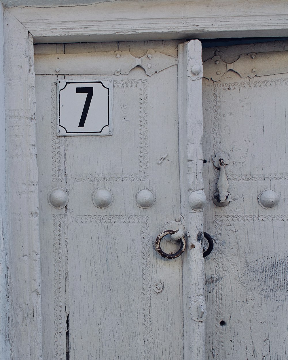 white wooden door with black and white number 7