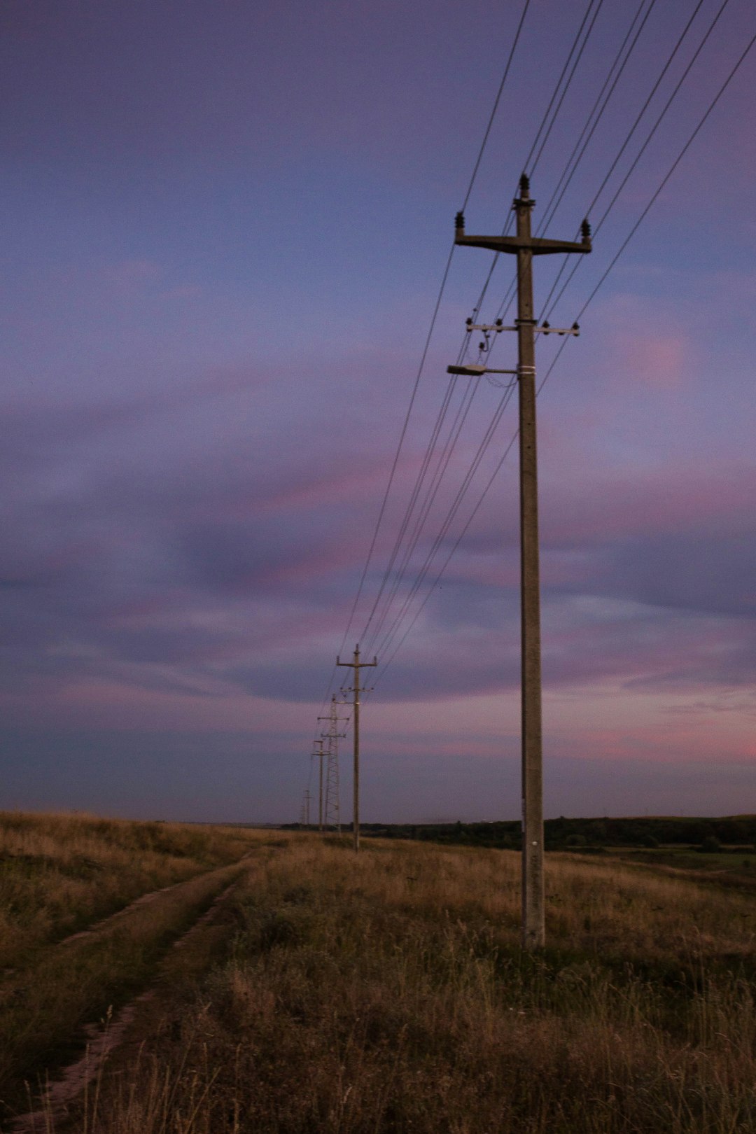 brown wooden electric post under cloudy sky during daytime