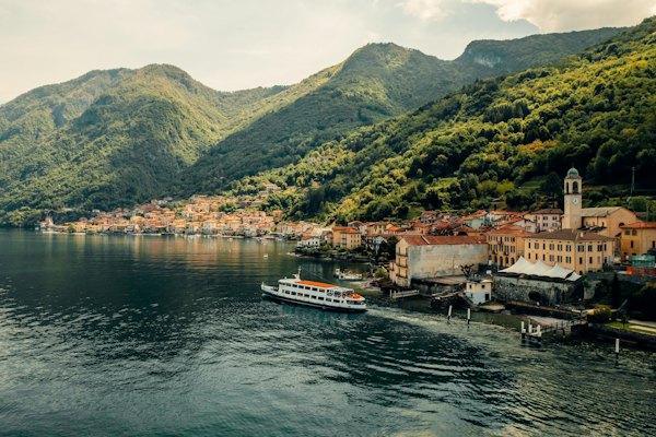 White and black boat on body of water near green mountain during daytime — Lake Como, Italy