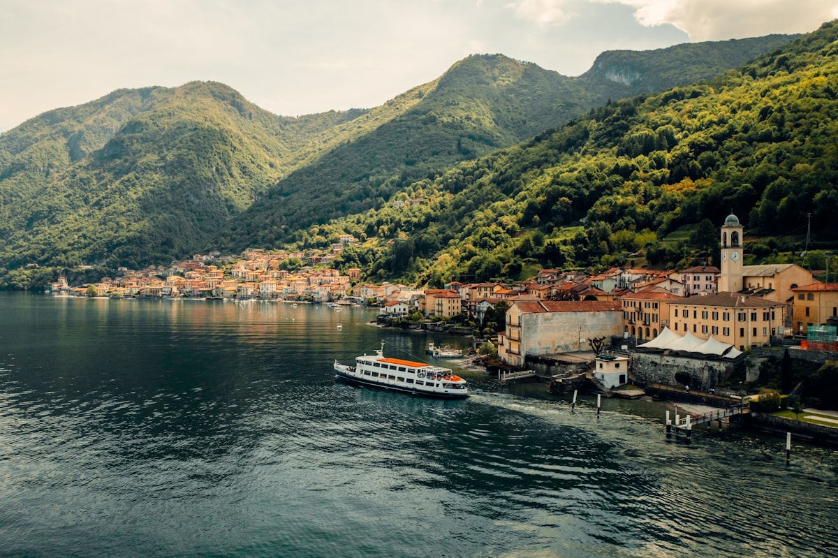 Menaggio lakeside promenade with mountains and ferry departing