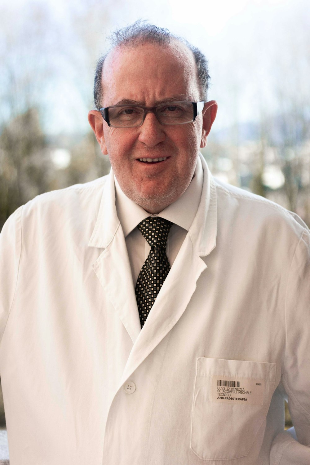 man in white coat wearing black framed eyeglasses