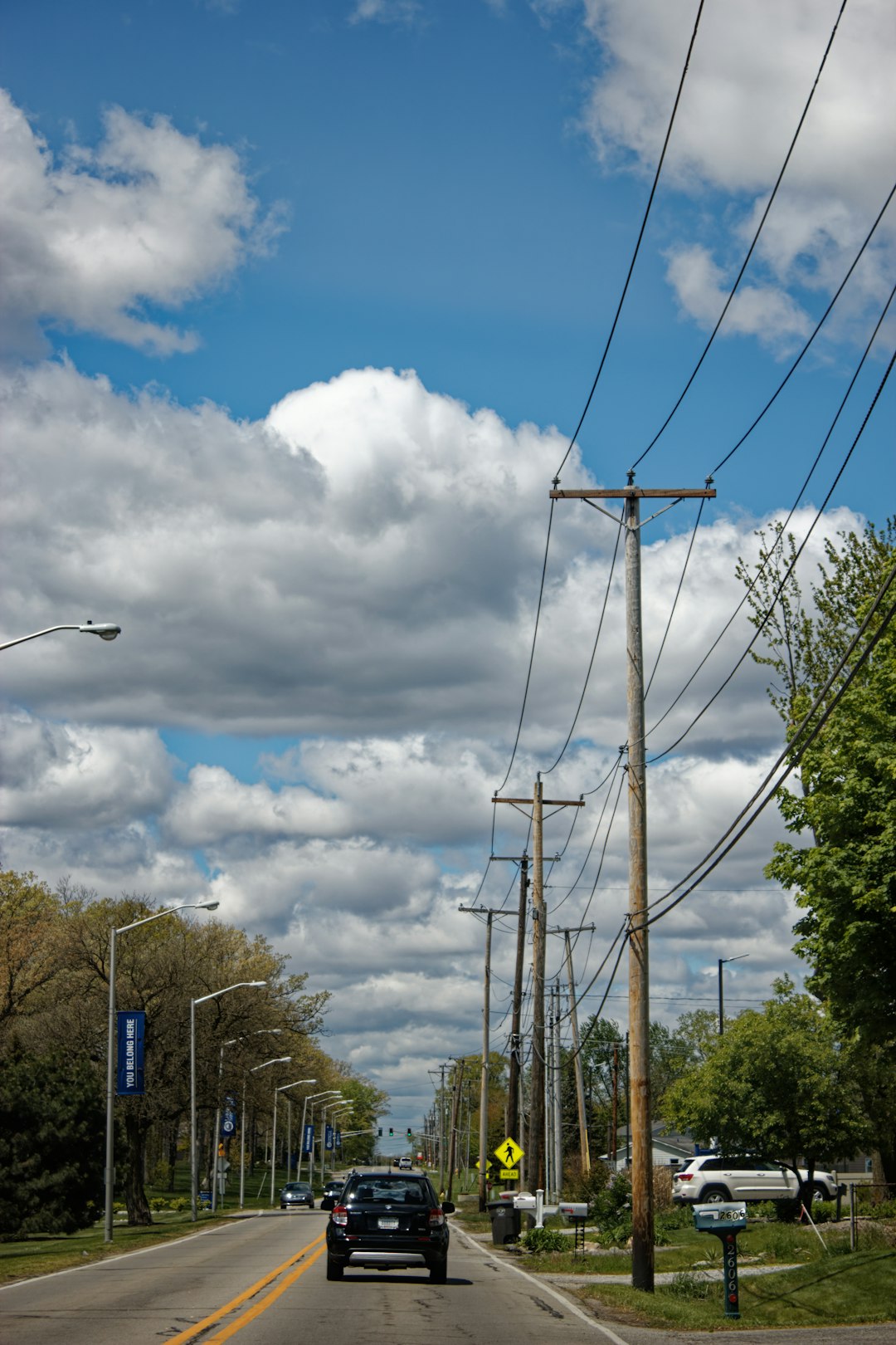 black street light under white clouds during daytime