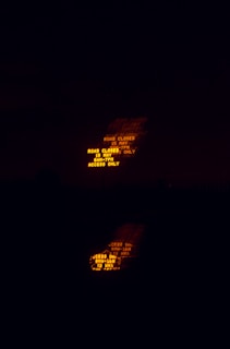A line of arrow boards and message centers glowing brightly against a deep charcoal black backdrop during a night closure.