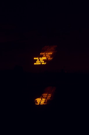 A line of arrow boards and message centers glowing brightly against a deep charcoal black backdrop during a night closure.