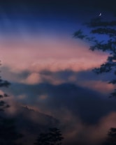 A serene landscape with a crescent moon in the upper right corner. Soft, pastel-colored clouds cover the sky, blending into a gradient from a deep blue to lighter pinkish hues. Silhouettes of trees and distant hills add depth to the scene, creating a tranquil and dreamy atmosphere.