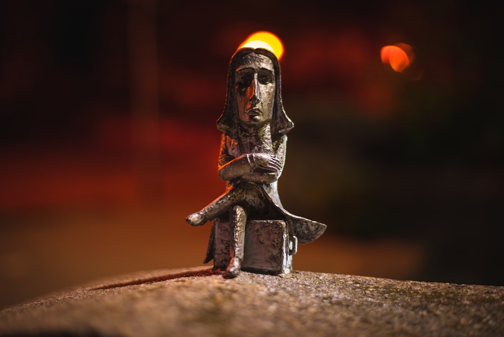 brown wooden figurine on brown concrete surface