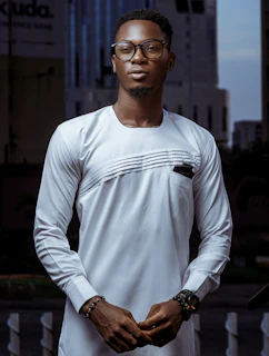 A stylish model showcasing a custom-fitted traditional outfit with modern flair against a city backdrop.