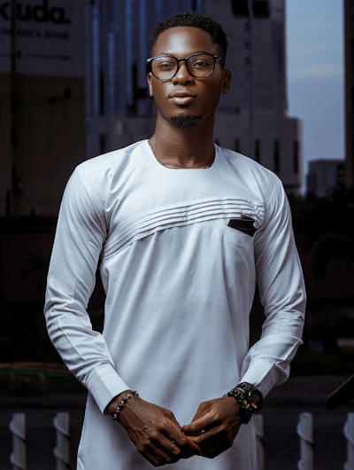 A stylish model showcasing a custom-fitted traditional outfit with modern flair against a city backdrop.