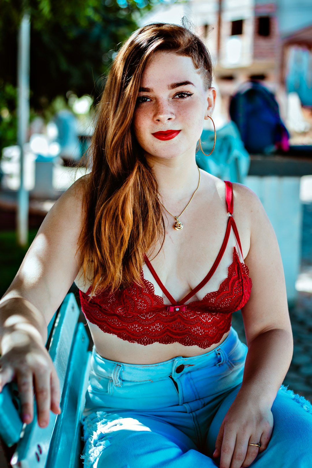 woman in red and blue floral brassiere and blue denim shorts