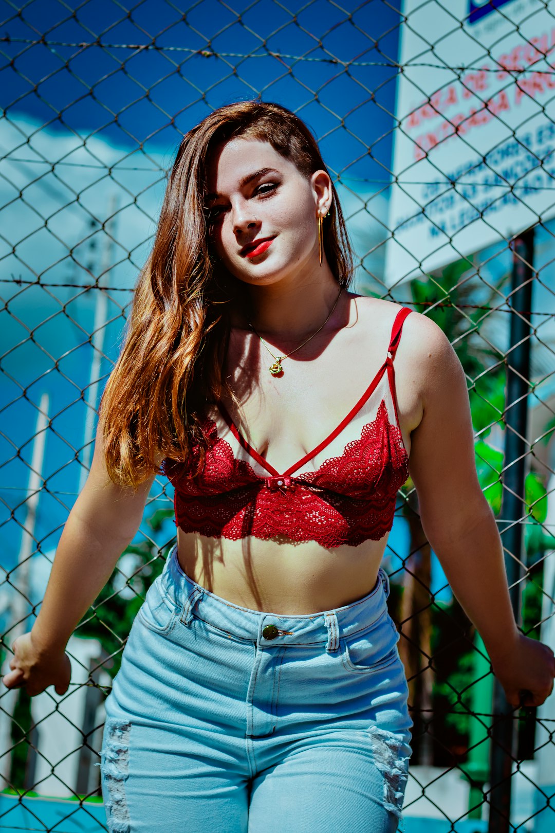 woman in red and black floral brassiere and blue denim shorts