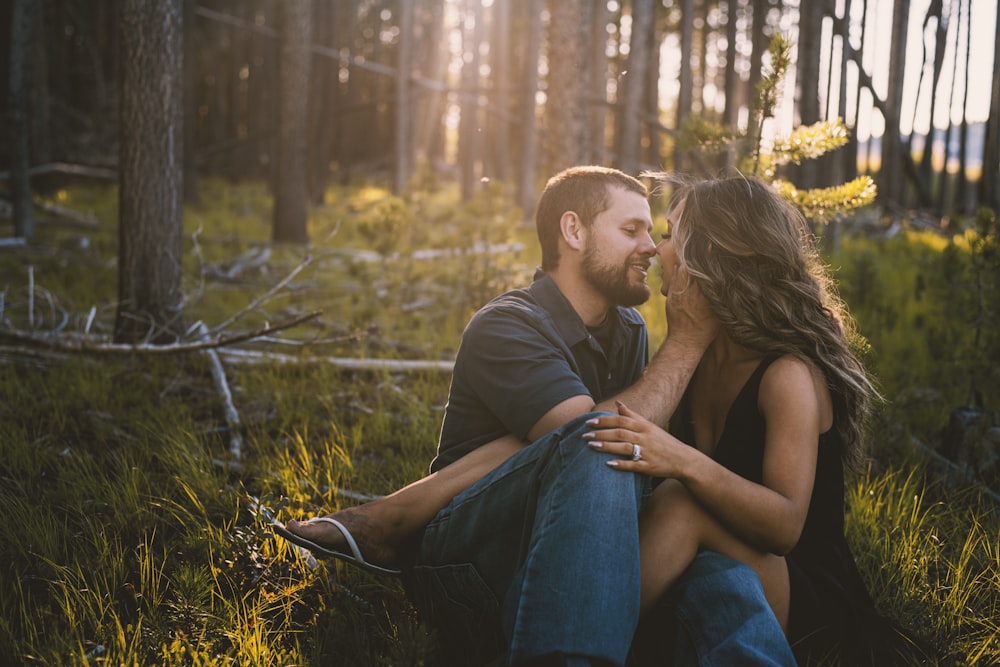 man and woman sitting on grass field during daytime