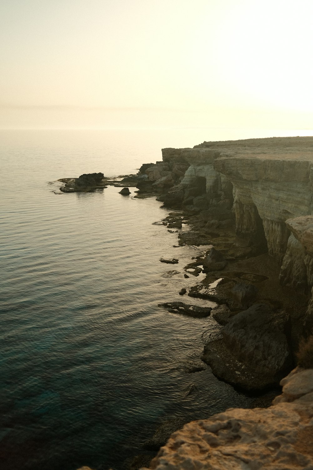 gray rock formation beside body of water during daytime