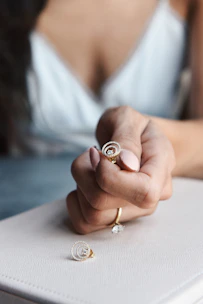 Elegant hands polishing a delicate gold ring under soft lighting.