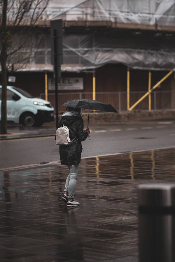 Person walking through rain in city wearing waterproof outfit
