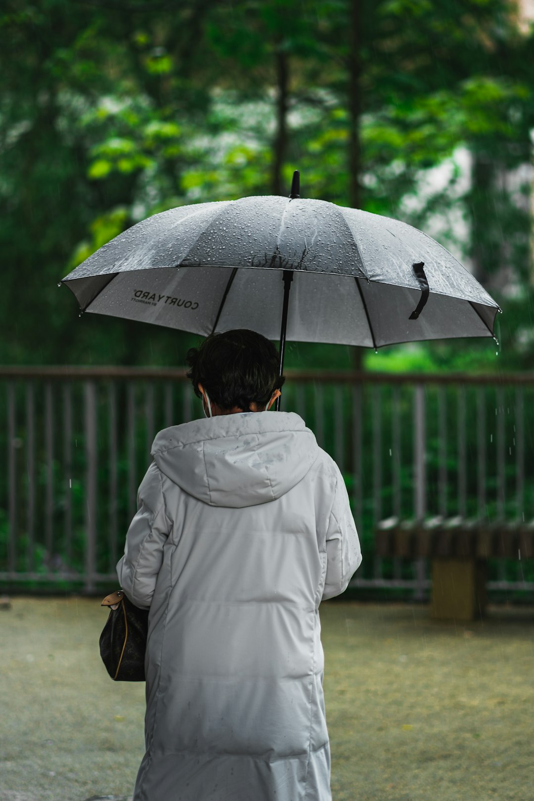 woman in white coat holding umbrella