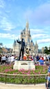people walking on park near disney castle during daytime