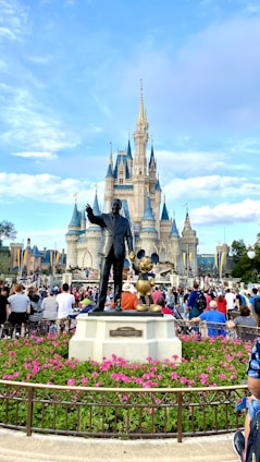 people walking on park near disney castle during daytime