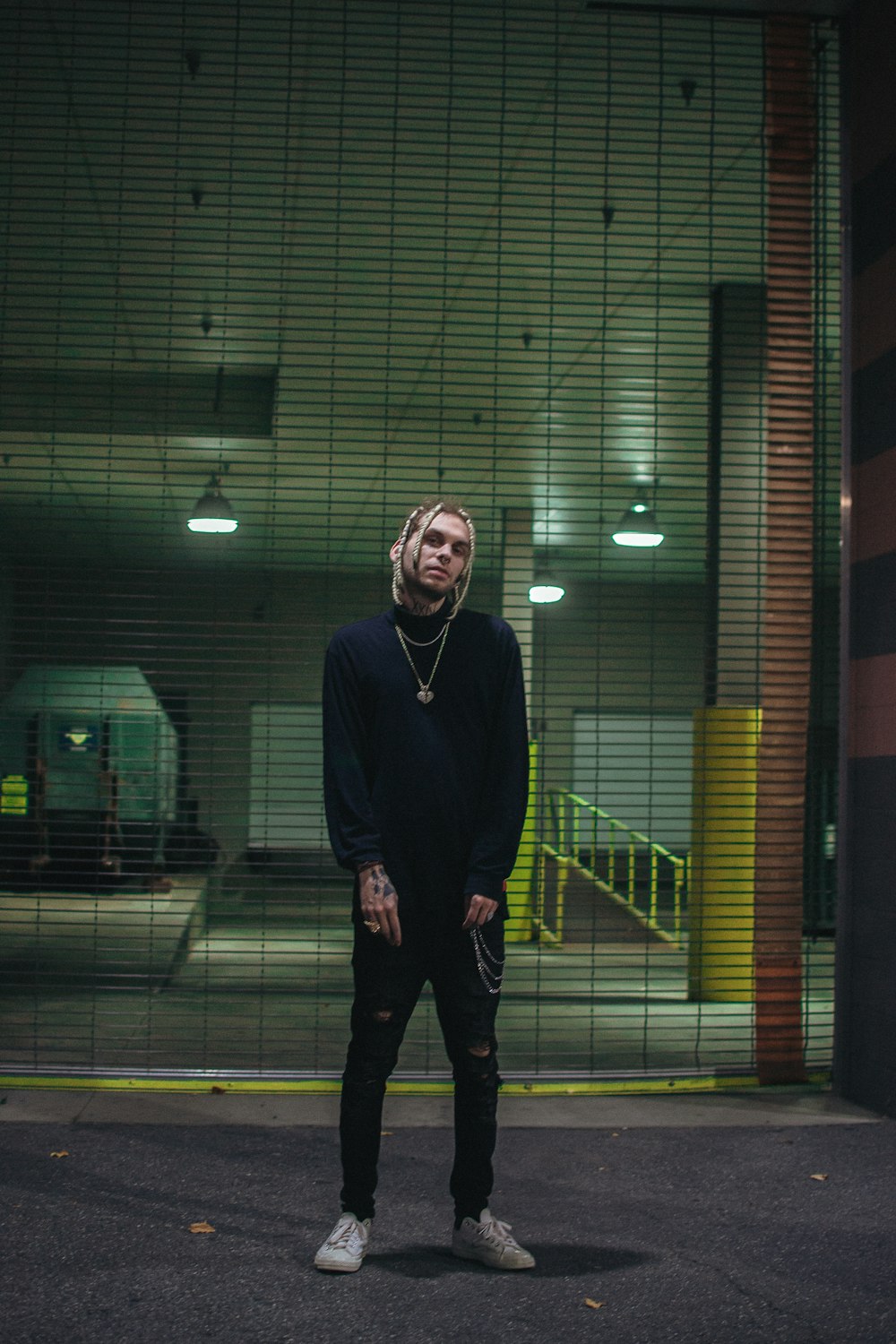 man in black sweater standing on sidewalk