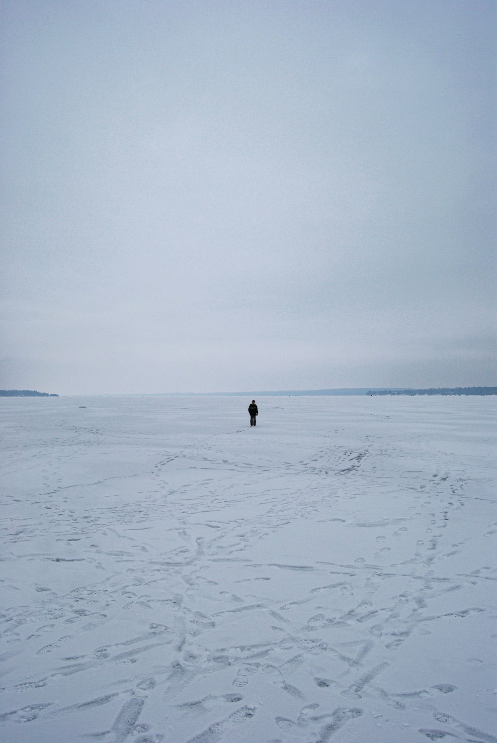 person walking on snow covered field during daytime