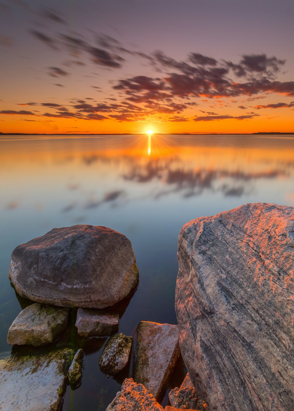 Graue und braune Felsformation in der Nähe von Gewässern bei Sonnenuntergang